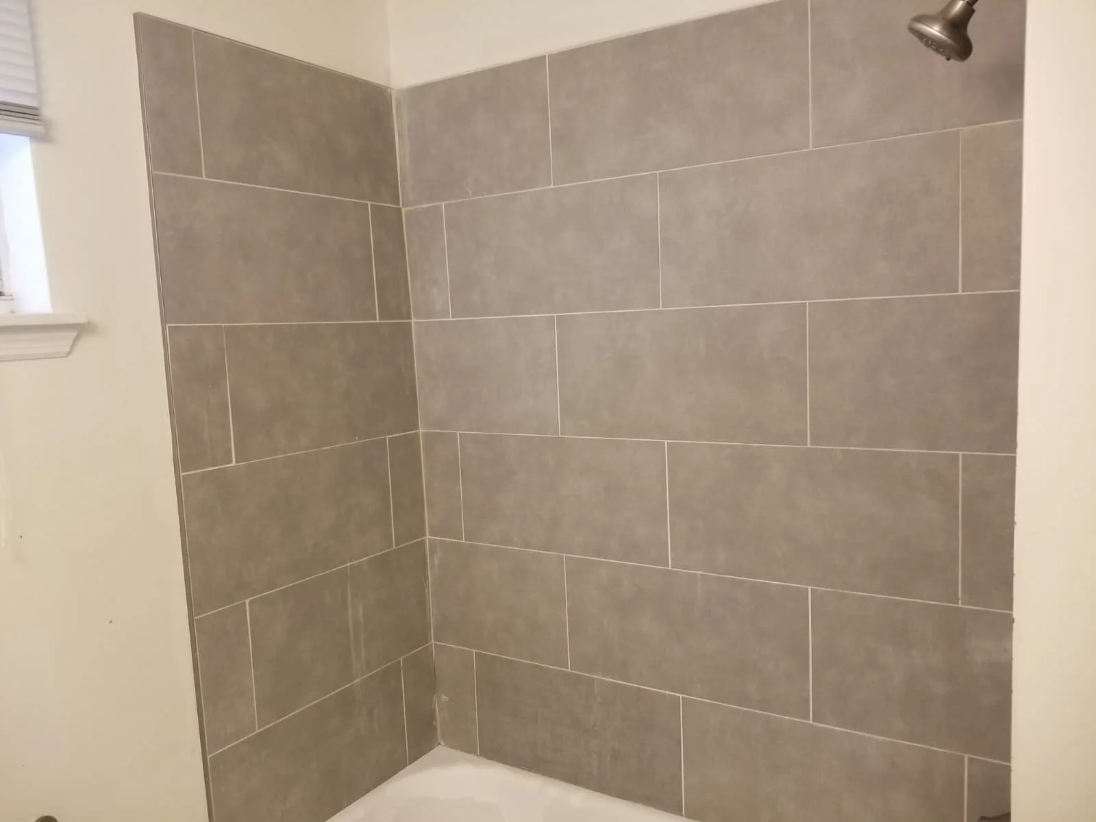Walk-in shower finished in gray large-format tile
