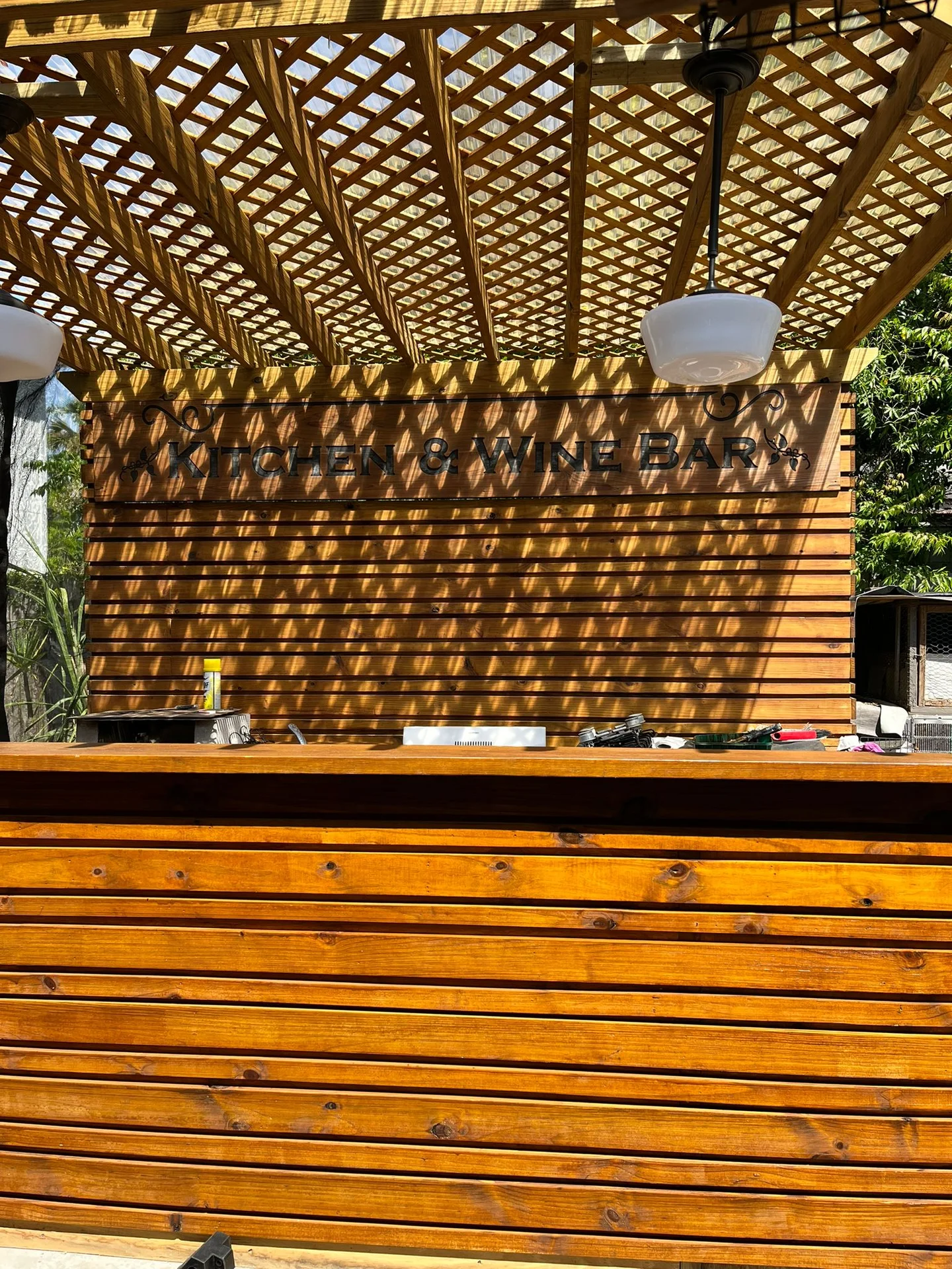 Outdoor wood pergola over a cedar bar and deck